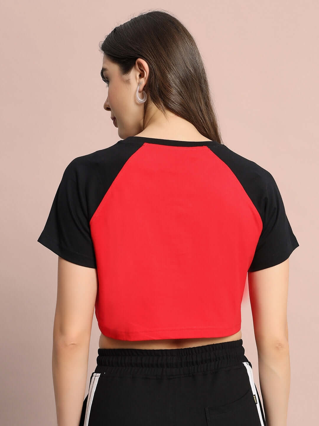 Back view of Women's Challenger Raglan Crop-Top in red and black, made from premium 100% cotton, showcased by a model.