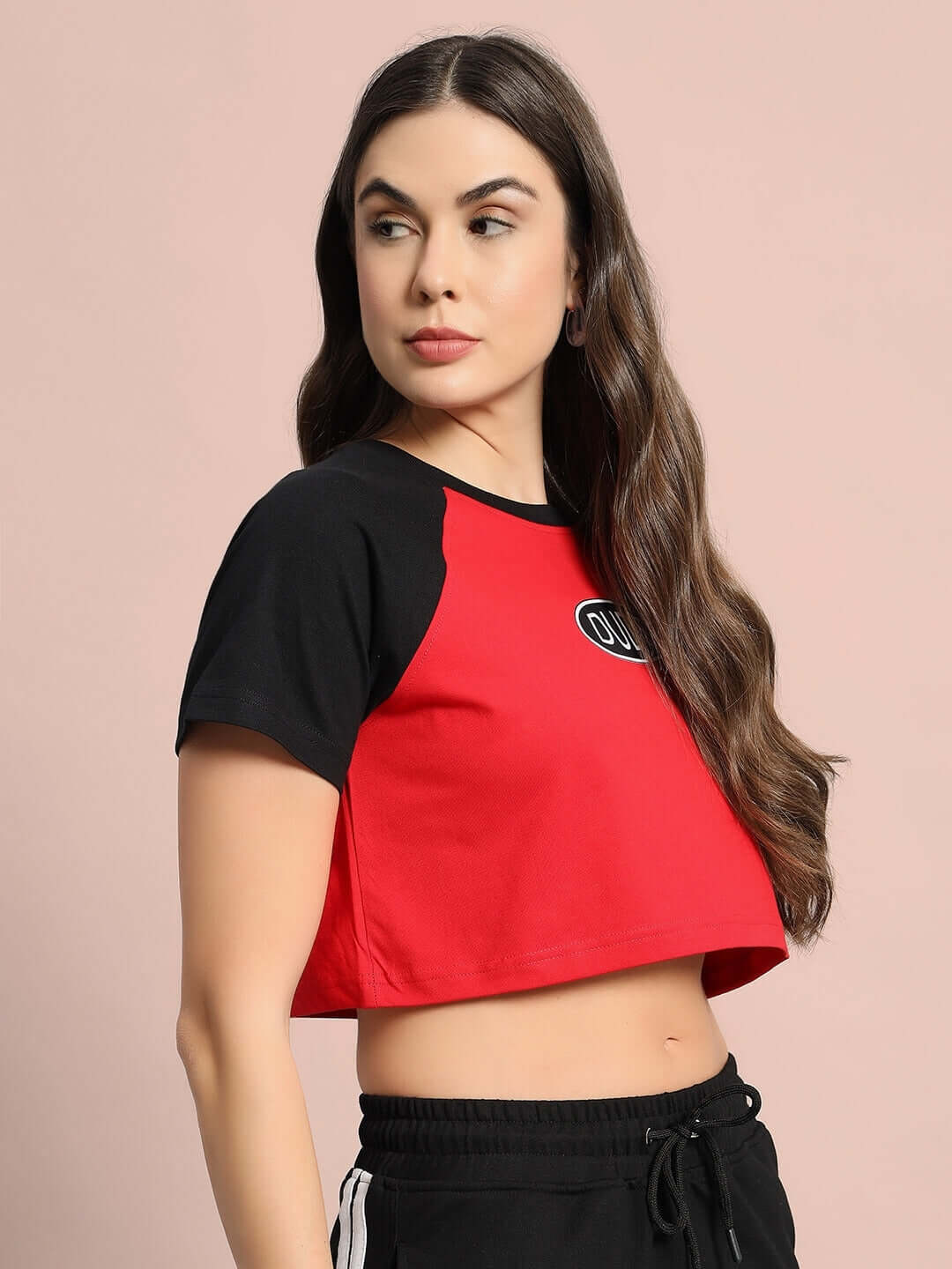 Model wearing women's red and black Challenger Raglan crop-top made of 100% cotton, showcasing premium quality and stylish design.