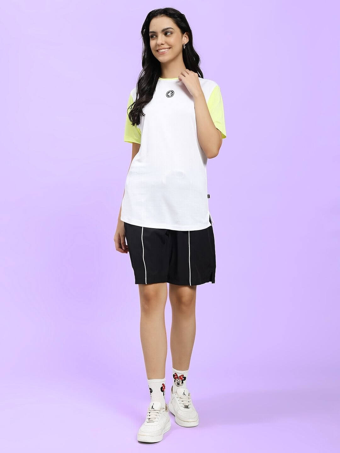 Woman wearing the WOMEN CHAMPION ZONE REGULAR FIT CO-ORD WHITE NEON BLACK, showcasing sporty and elegant streetwear style.