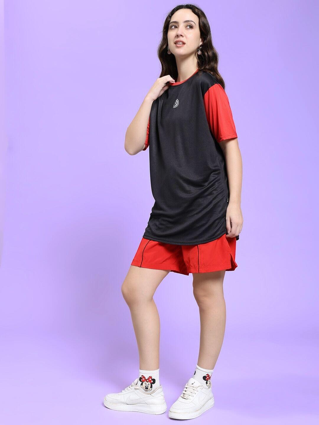 Woman wearing WOMEN CHAMPION ZONE REGULAR FIT CO-ORD SET BLACK RED against purple background, showcasing sporty and stylish design.