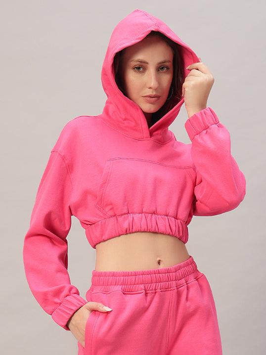 Woman wearing WOMEN CHARM OVER-SIZED FLEECE CROP HOODIES PINK with hood up, showcasing cozy and chic street-style fashion.