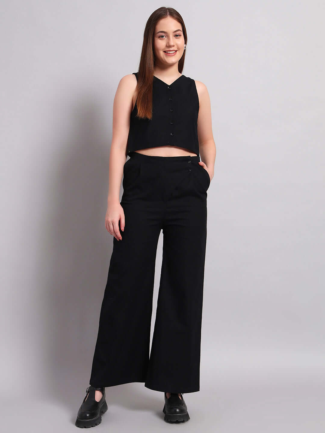 Model wearing a stylish black two-piece outfit, featuring a sleeveless top and wide-leg pants, ideal for chic casual wear.