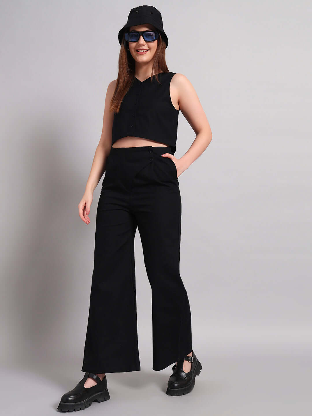 Woman modeling black relaxed fit jogger and matching top, styled with sunglasses and a hat. Ideal for casual and chic outfits.