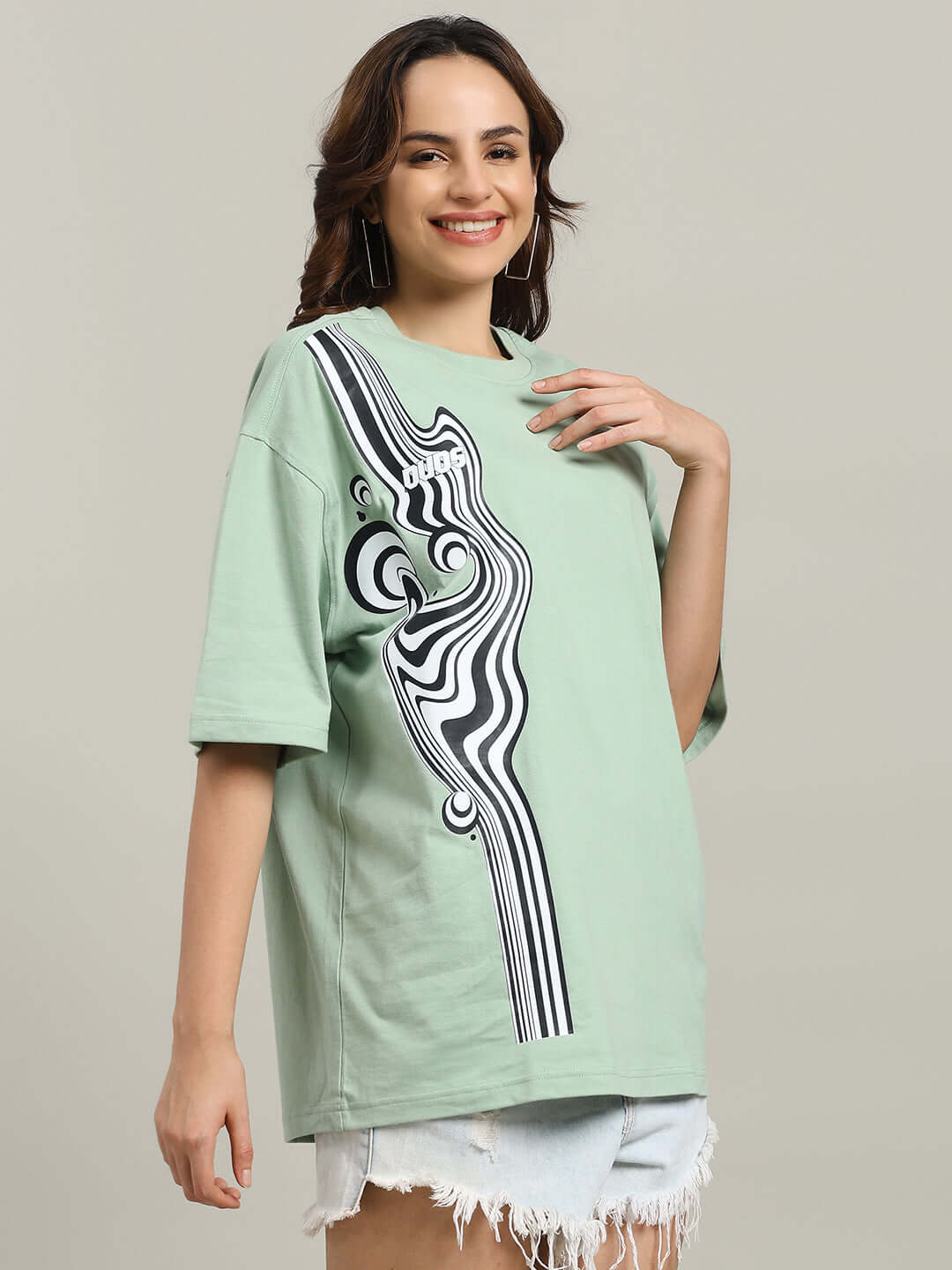 Woman wearing Nyanza Green Chimera oversized T-shirt with graphic design, made from premium cotton French terry. Casual fashion look.