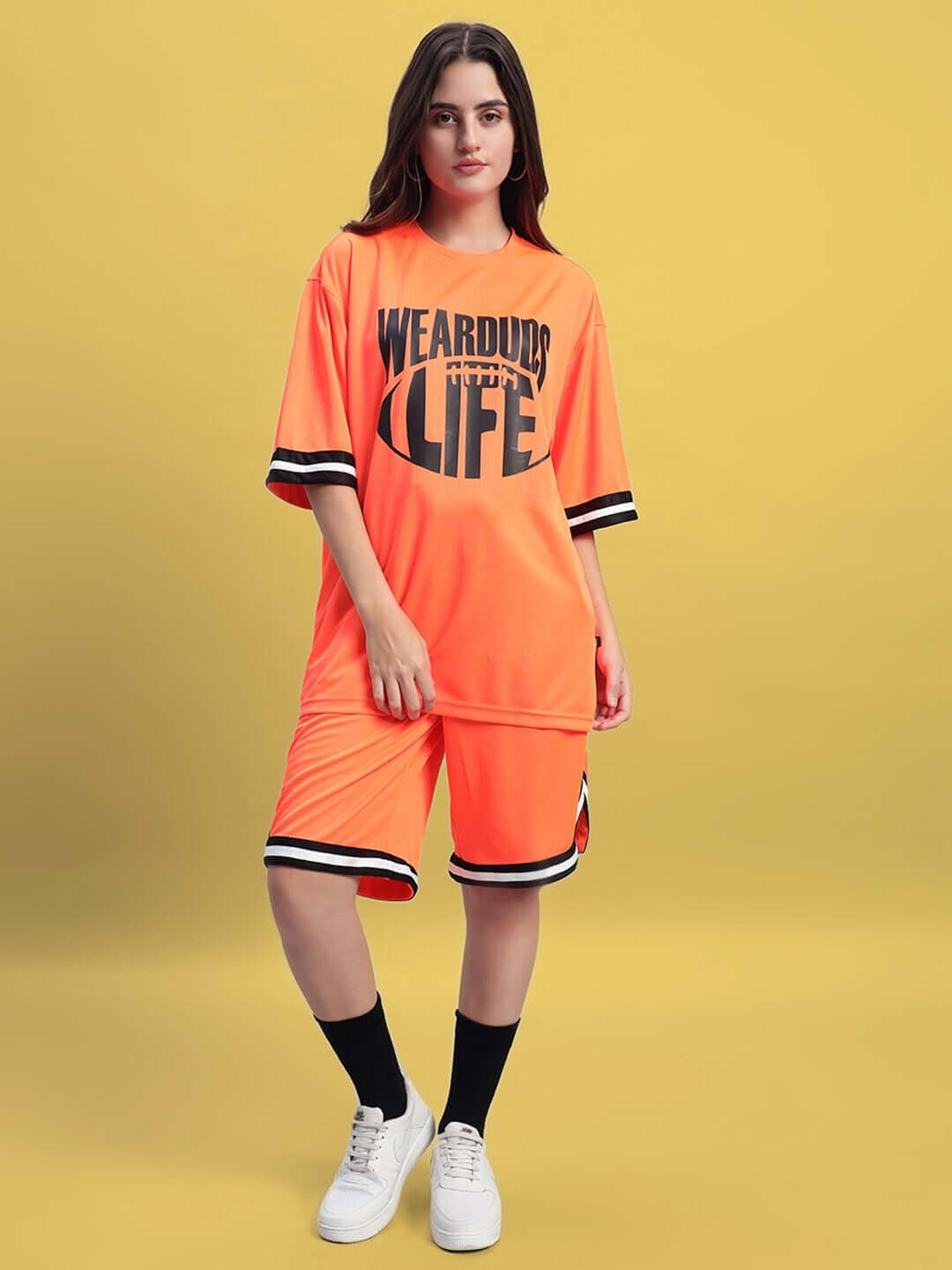 Woman wearing WOMEN'S CHRONIC COLORBLOCK CO-ORD SET ORANGE, featuring vibrant orange color and trendy casual style.