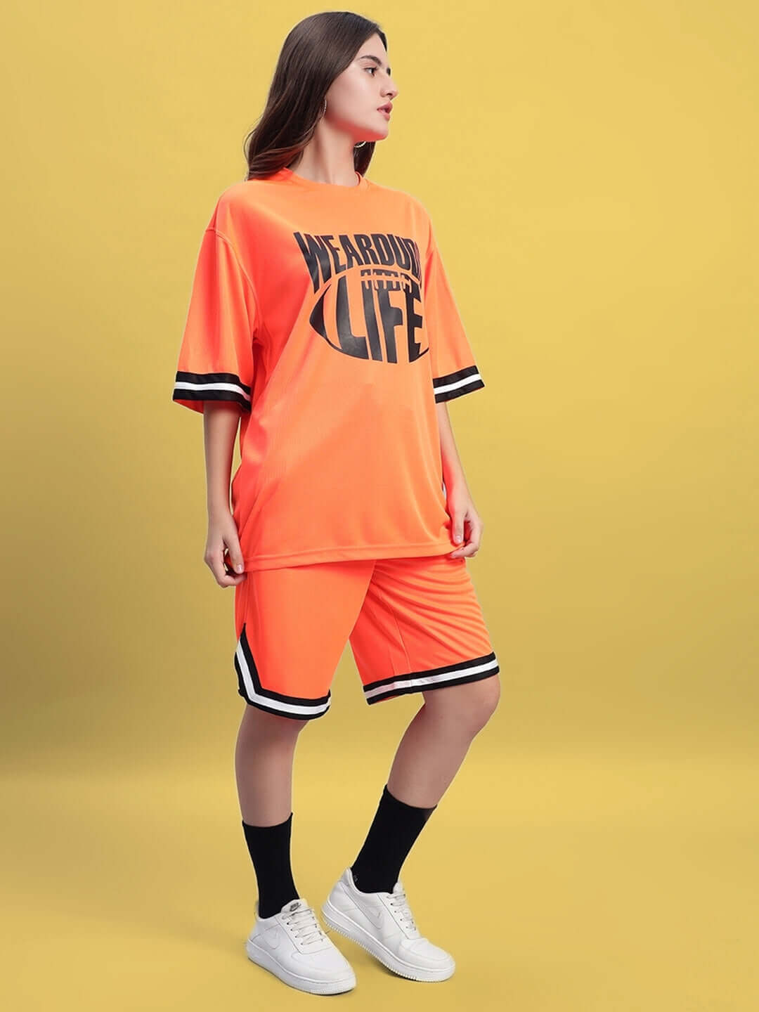 Woman wearing WOMEN'S CHRONIC COLORBLOCK CO-ORD SET ORANGE, featuring a vibrant colorblock design with bold orange accents, casual style.