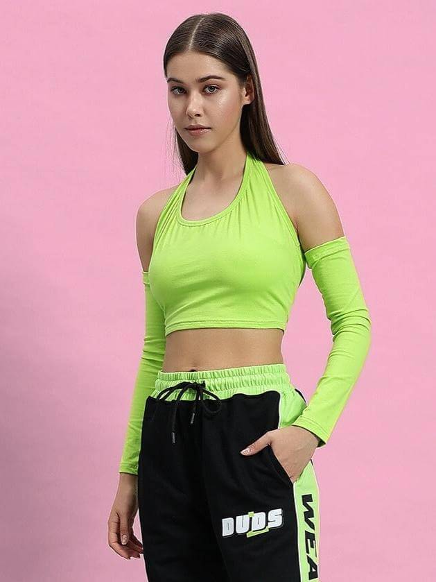 Stylish woman wearing WOMEN CLUTCH CROP-TOP NEON GREEN against pink background showcasing trendy fashion.