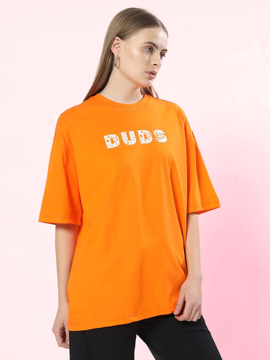 Woman wearing the Women Courage Over-Sized T-Shirt Orange with 'BUDS' graphic, showcasing relaxed fit and bold style.