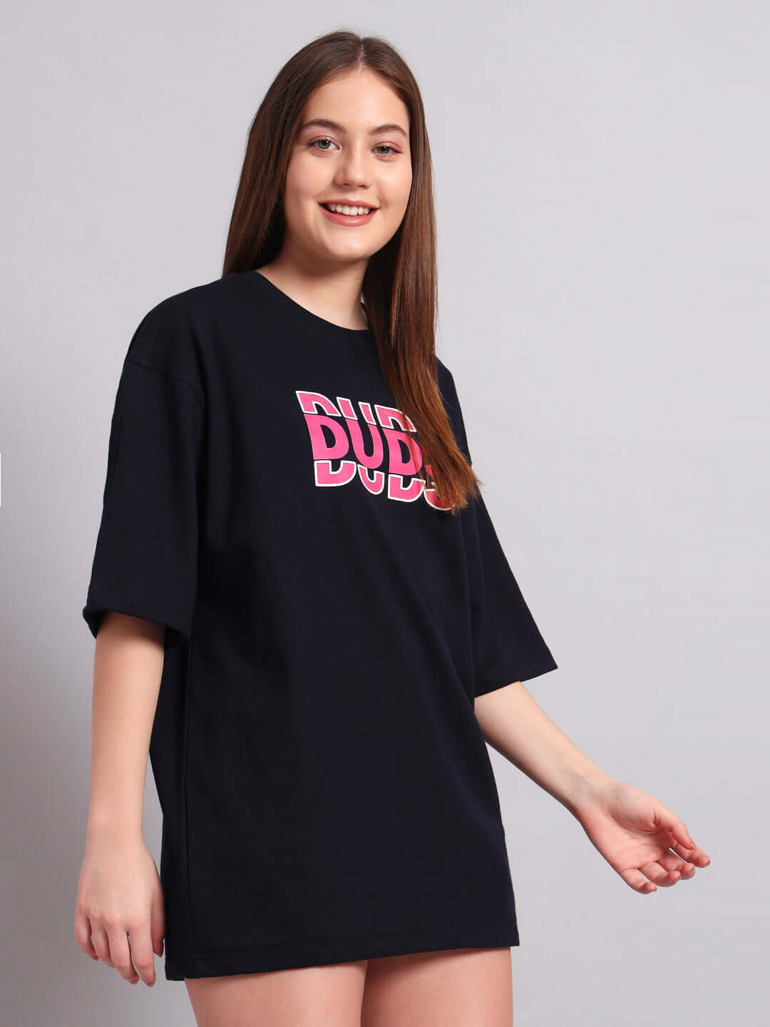 Woman wearing a navy blue oversized T-shirt with a pink creative print, made from premium cotton elastane blend fabric.