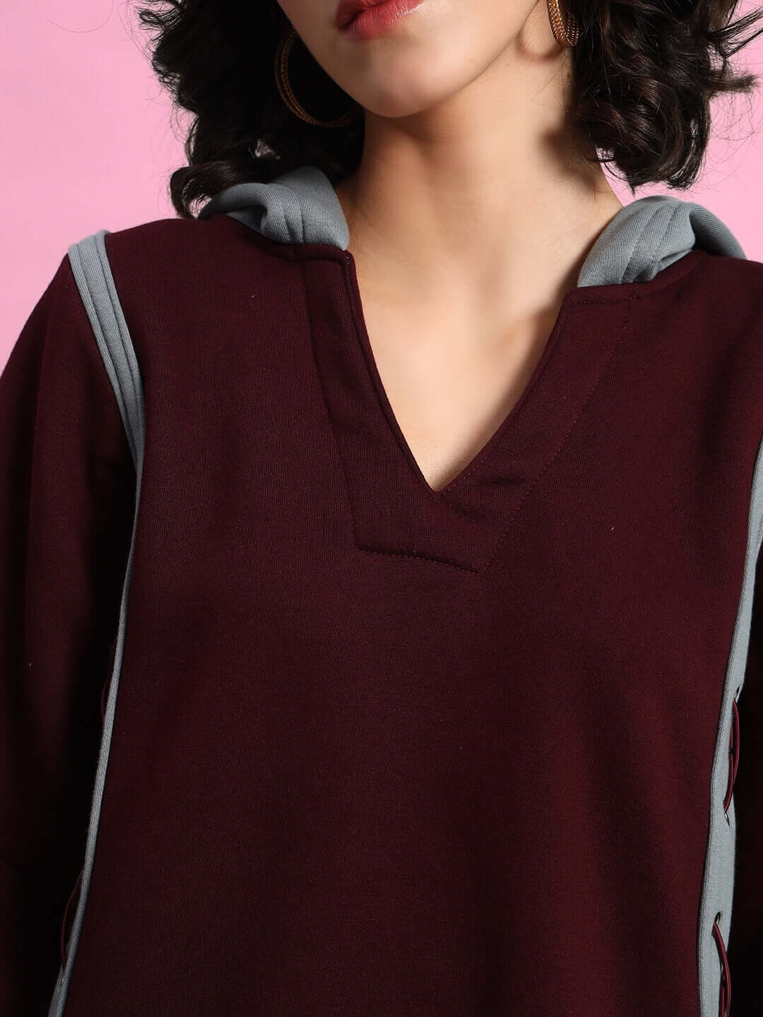 Woman wearing WOMEN CRISS CROSS FLEECE HOODIE WINE GREY, featuring a stylish V-neck and contrasting grey accents.