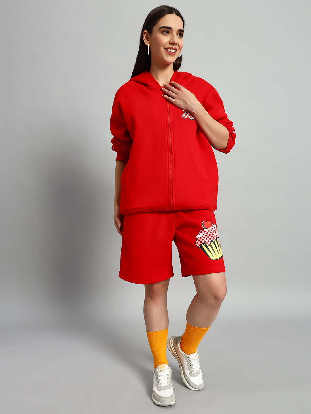 Woman wearing WOMEN CUPCAKE FLEECE CO-ORD RED with hoodie and shorts set, showcasing modern streetwear fashion.