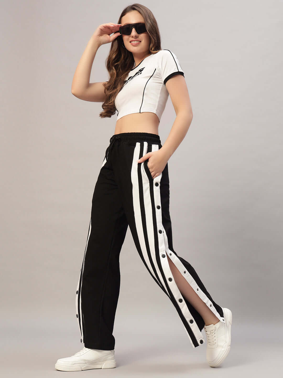 Woman wearing black and white women's dancer joggers from DUDS, styled with a white crop top and sunglasses.