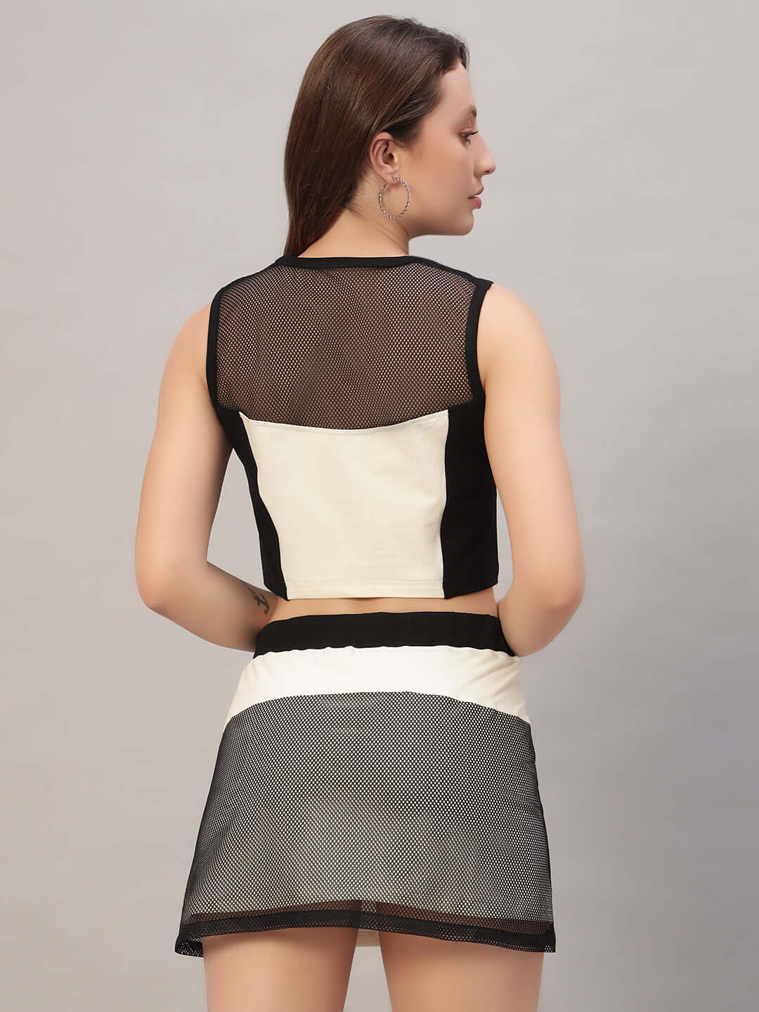 Back view of a woman wearing an off-white co-ord set with mesh detailing, featuring premium cotton fabric. Fashion and style.