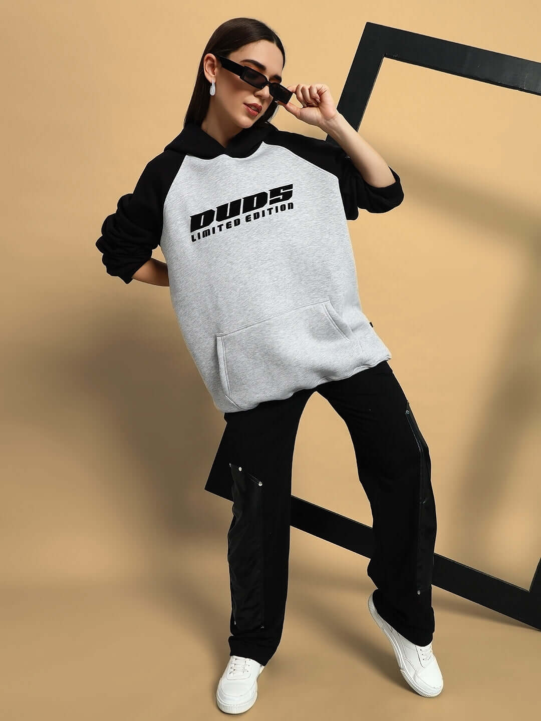 Woman wearing WOMEN DELUXE FLECCE OVERSIZE HOODIE BLACK MELANGE GREY with sunglasses striking a pose