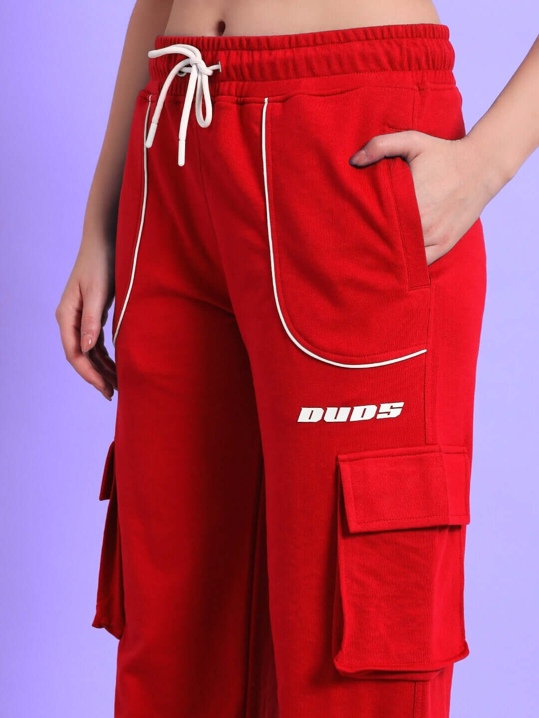 Red women's relaxed-fit joggers by DUDS with pockets, drawstring waist, and white piping detail.