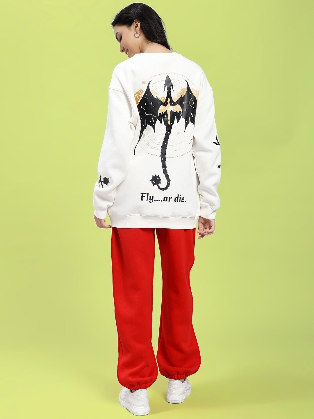 Model wearing WOMEN FLY OR DIE DRAGON PRINT FLEECE COORD OFF WHITE RED with dragon design on back.