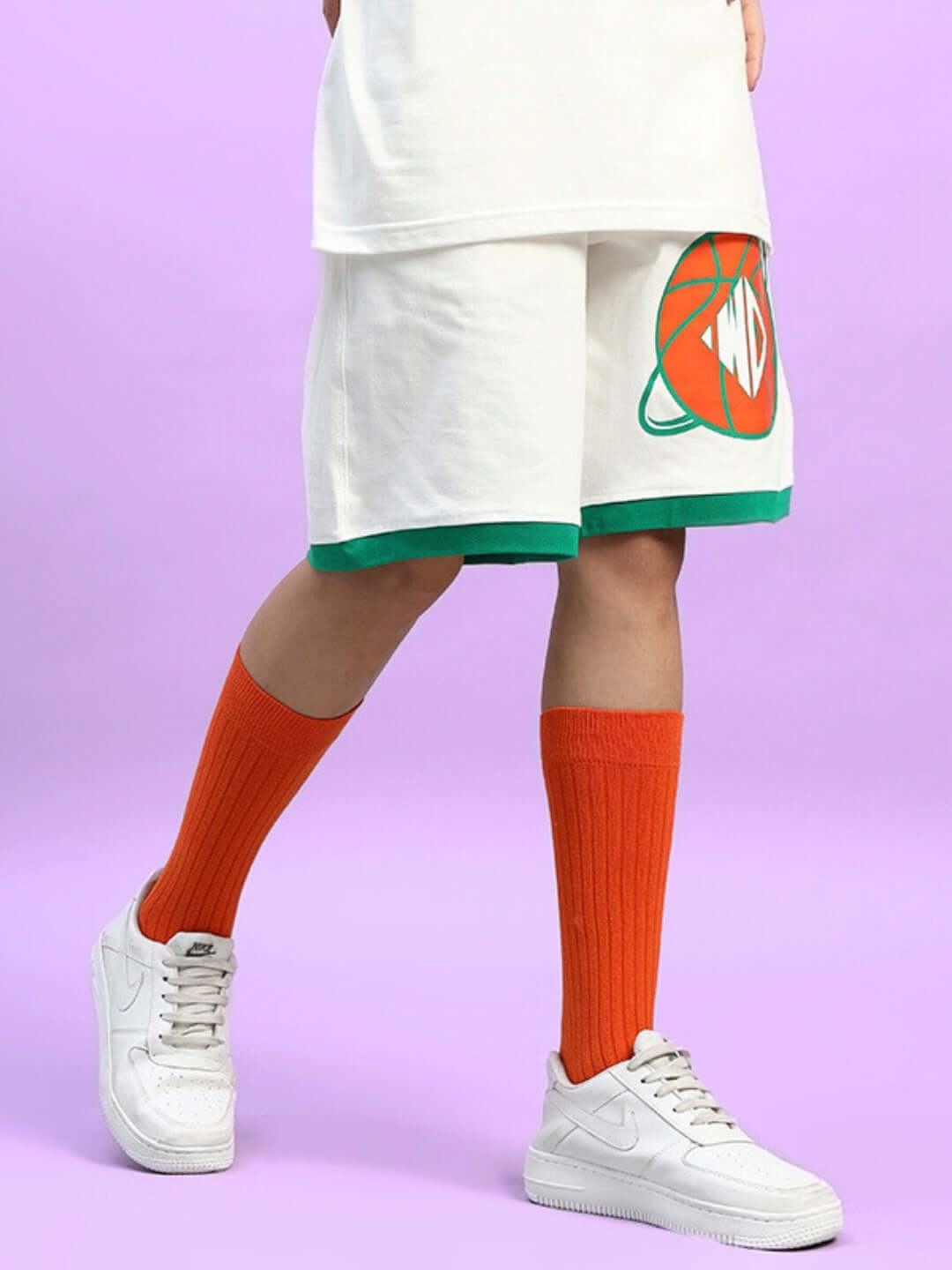 WOMEN'S DRIBBLE SUMMER SHORTS OFF-WHITE styled with orange socks and white sneakers against a purple background