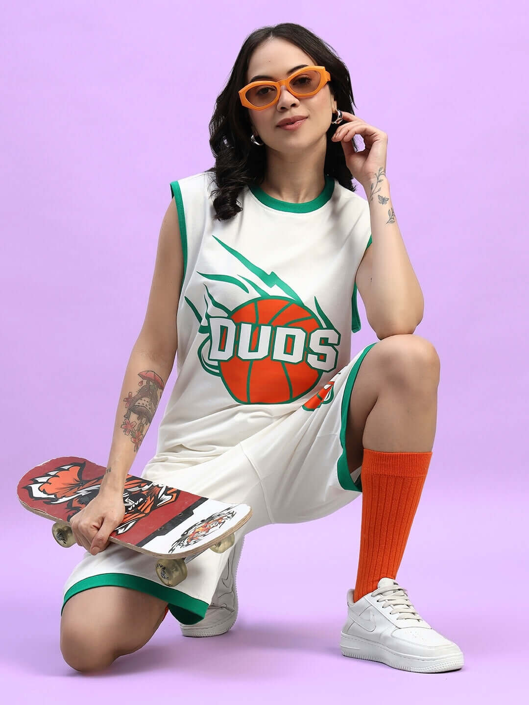 Woman in basketball-themed outfit posing with skateboard