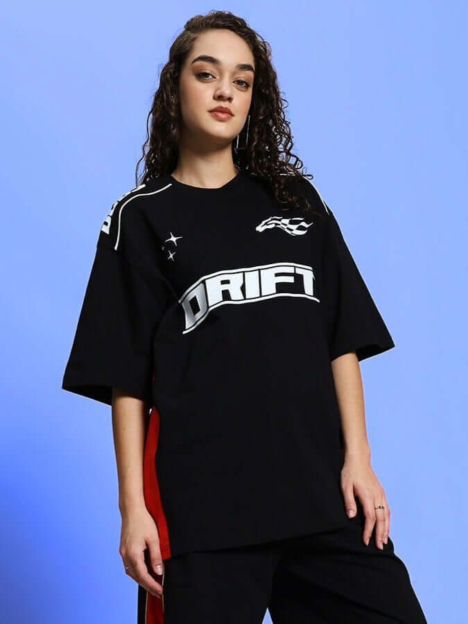 Black women's drift oversized T-shirt with bold design, customizable fit, worn by a model against a blue background.