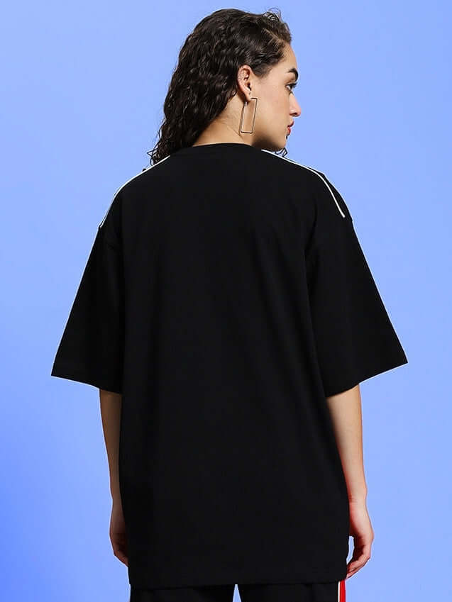 Back view of woman wearing black oversized Drift T-shirt by DUDS; available in custom fit for prepaid orders.