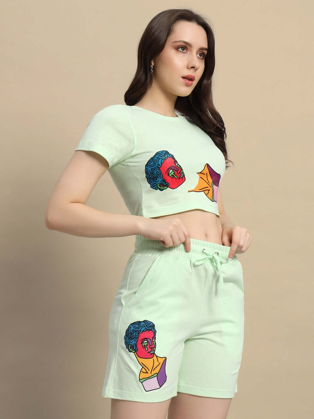 Woman wearing women's Drip God co-ord set in nyanza green with artistic print, made from premium cotton fabric, standing against neutral background.