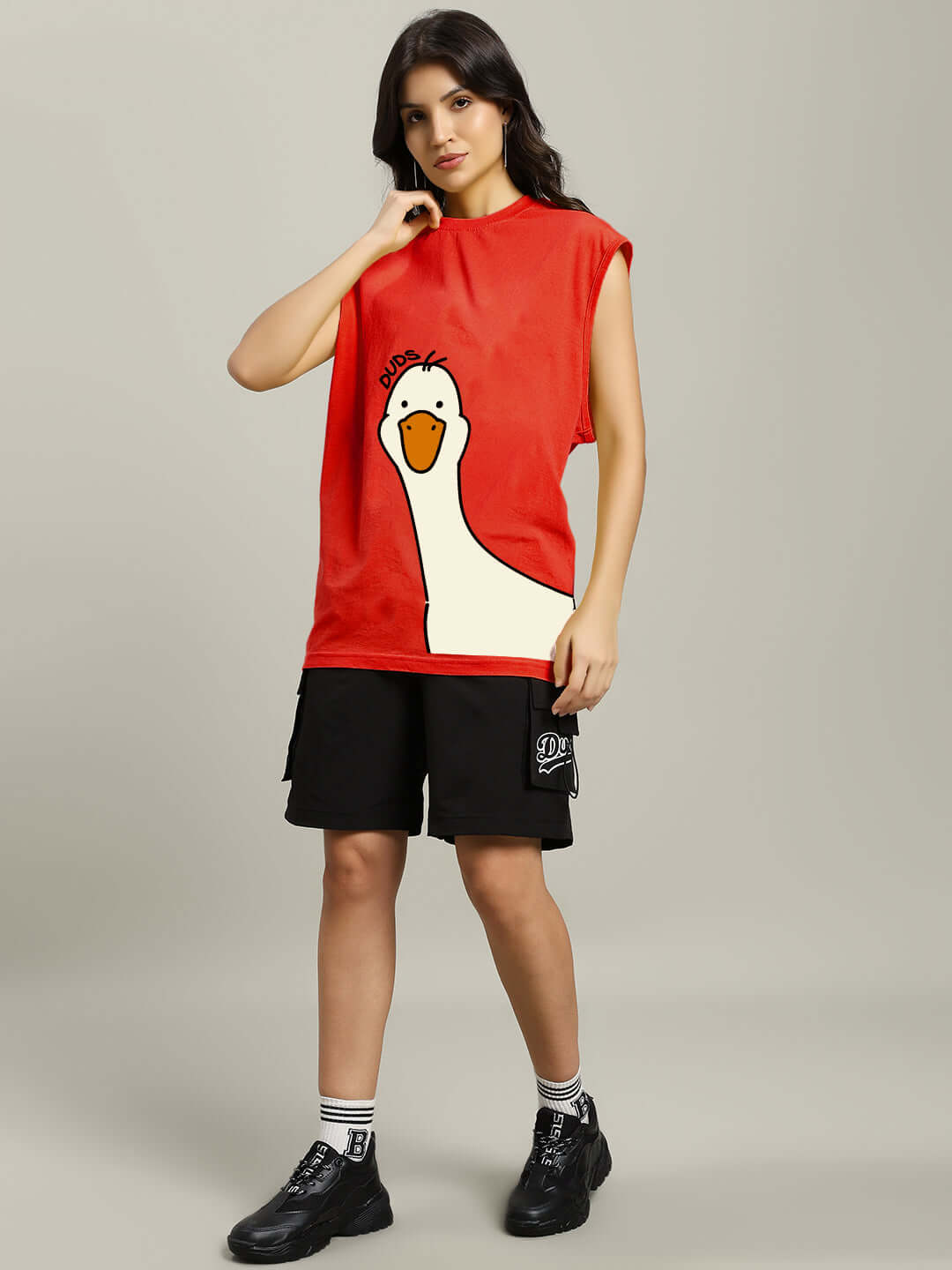 Woman wearing a red gym t-shirt featuring a duck print, styled with black shorts, embodying sporty and fun fashion.