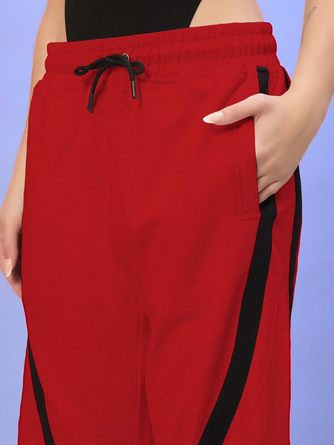 Close-up of red women's joggers with black stripe, showcasing pocket and drawstring waist, custom fit available.