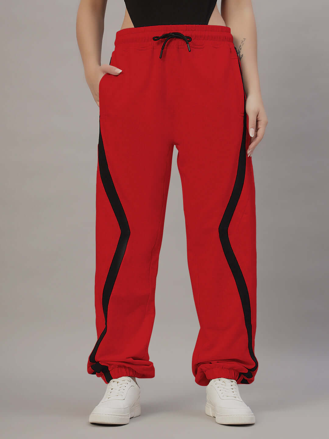 Woman wearing red DUDS frame joggers with black stripe detail, designed for comfort and custom fit option available.
