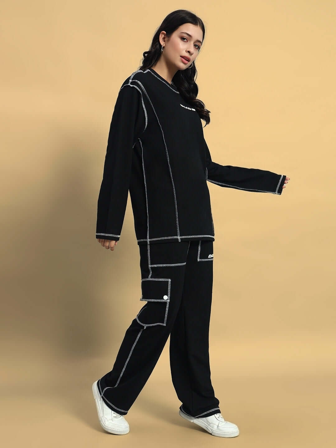 Model wearing women's black oversized co-ord set with contrast panel joggers, showcasing relaxed unisex fit and elasticated drawstring waist.