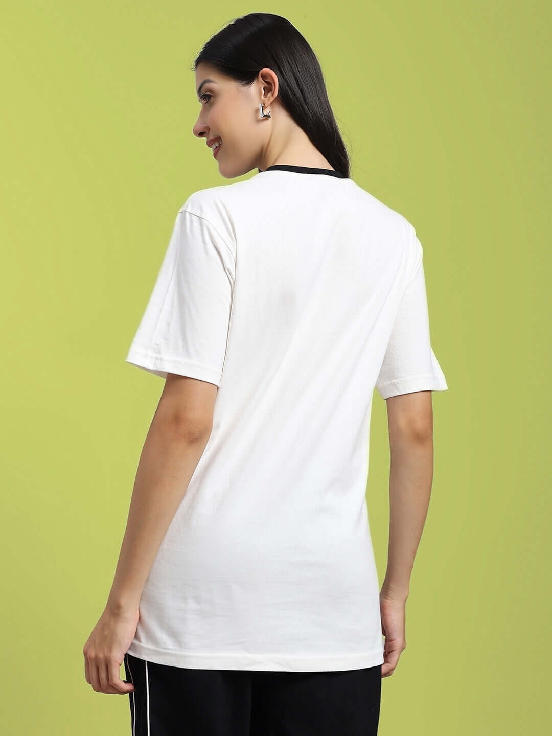 Model wearing white Women's Eagle Wings T-shirt, regular fit, showcasing back design on green background.