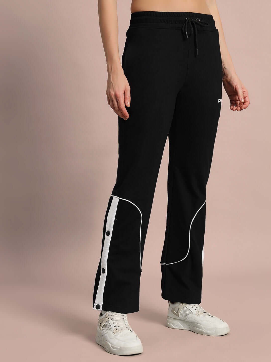 Woman wearing Women's Eddie Contrast Joggers in black, featuring white side stripe accents, designed for comfort and style by DUDS.