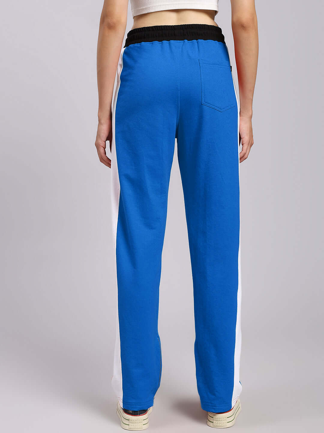 Back view of women's blue relaxed-fit joggers with white side stripes.