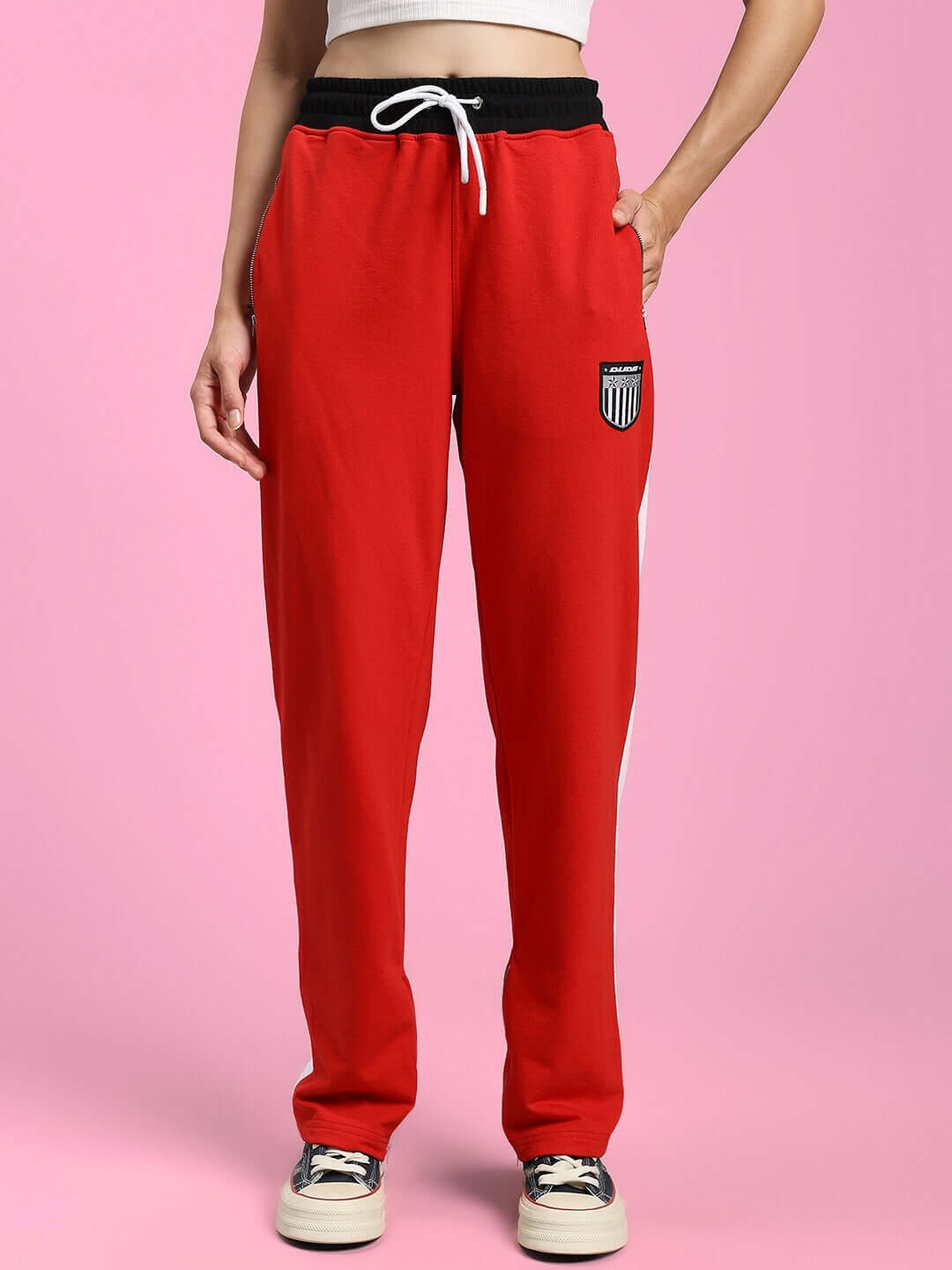 Woman wearing WOMENS ELEGANT RELAXED-FIT JOGGERS RED with black waistband, standing on pink background.