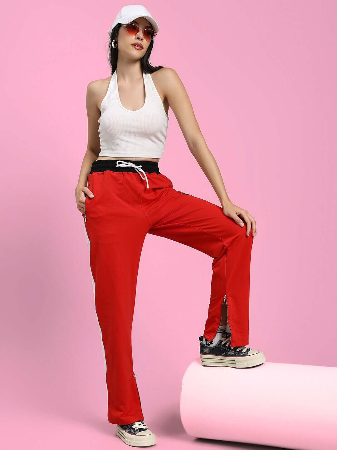 Woman modeling WOMENS ELEGANT RELAXED-FIT JOGGERS RED paired with a white tank top and sneakers.