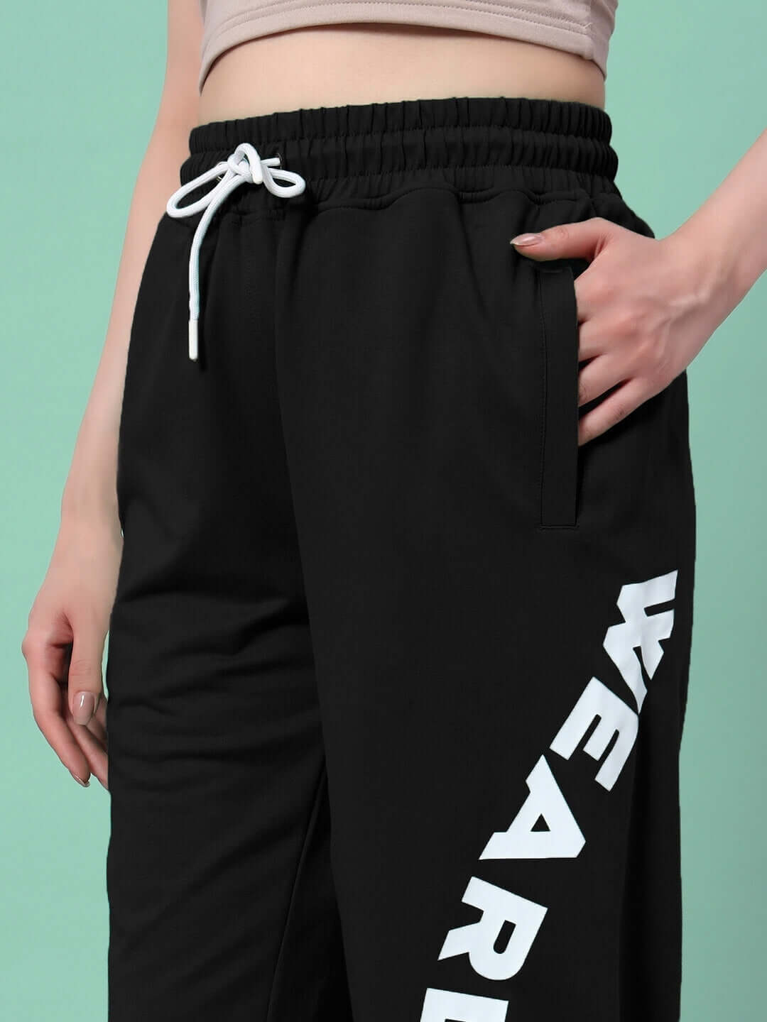 Woman wearing WOMEN'S ELLEN RELAXED FIT JOGGER BLACK with drawstring waist and stylish side print.