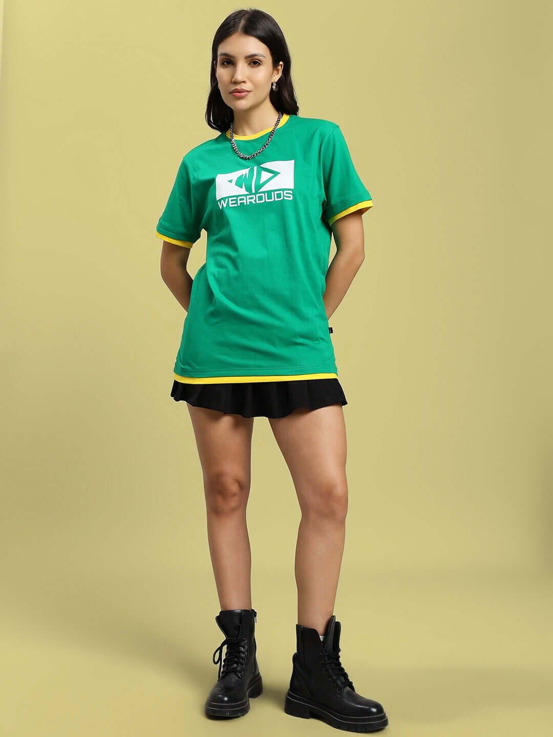 Woman in green Elmer regular fit t-shirt, 100% cotton, wearing black skirt and boots. Casual stylish outfit.