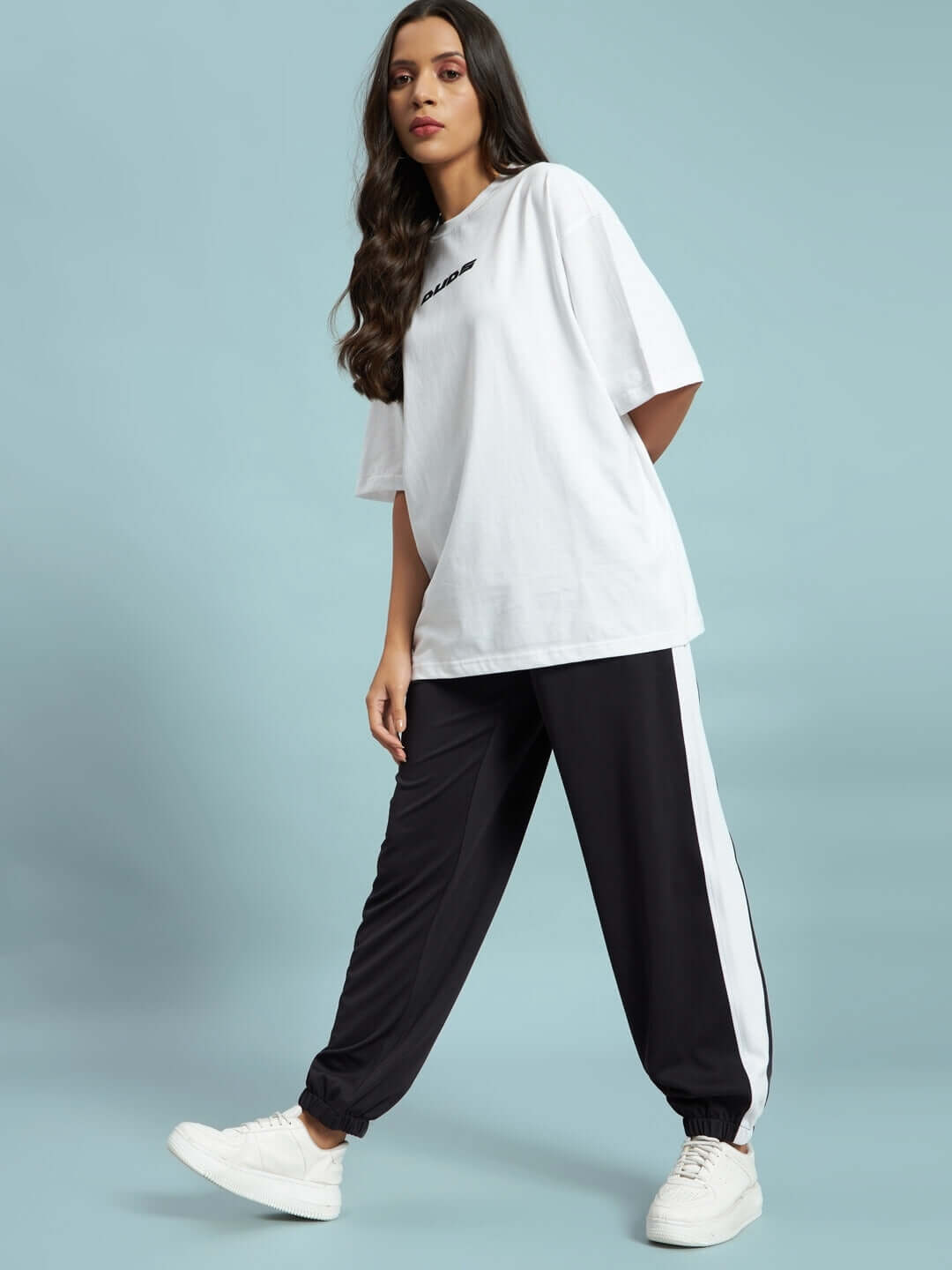Model wearing Women's Euphoria Joggers in Black-White, paired with white sneakers and a casual white tee.