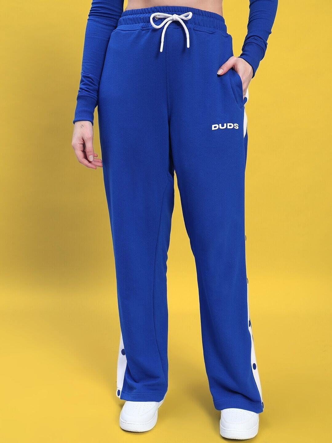 Model wearing the WOMEN'S EZEL CO-ORD SET ROYAL BLUE-WHITE showcasing sleek blue pants with white accents.