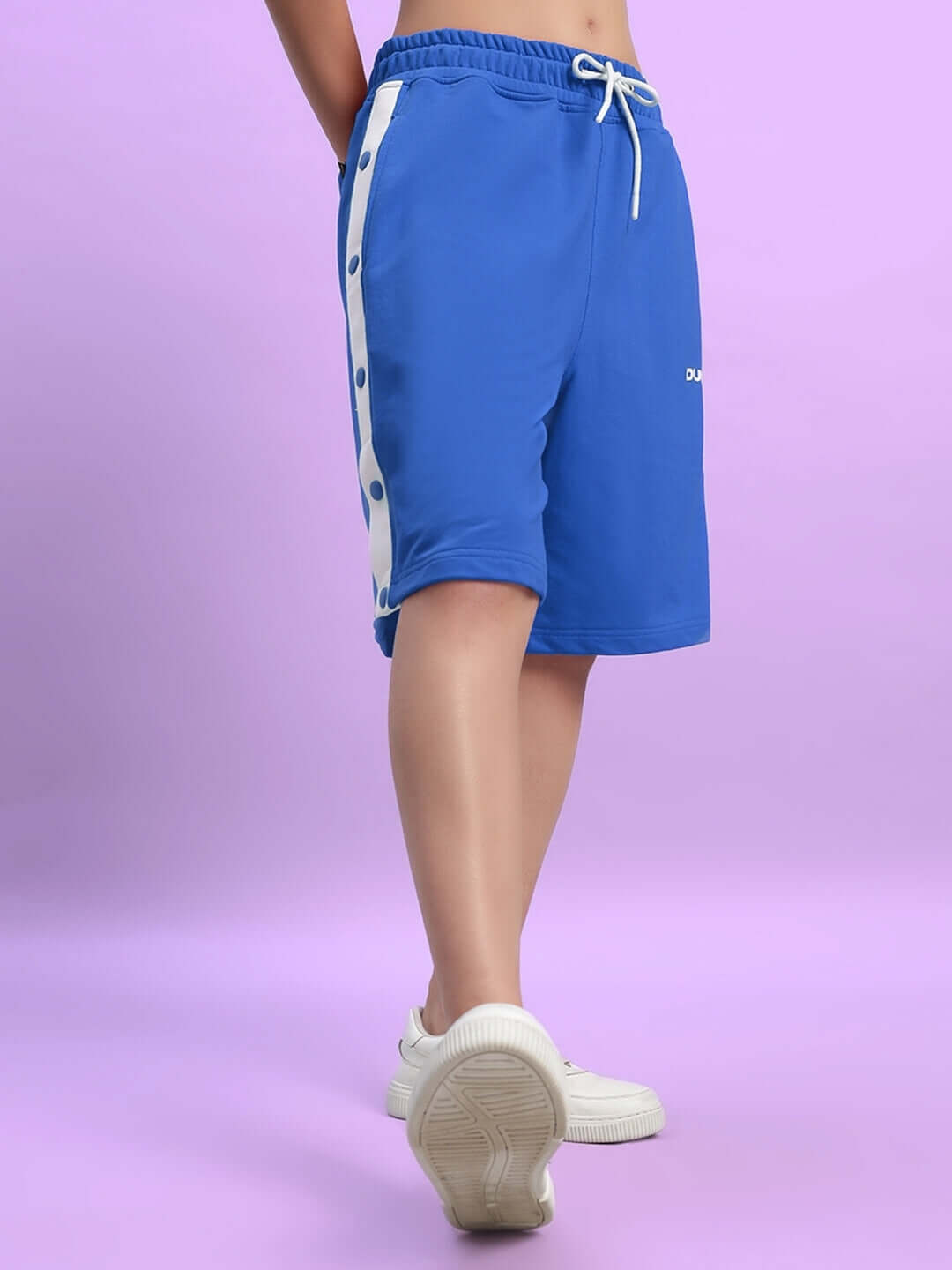 Woman wearing blue regular fit shorts with white side stripe and buttons.