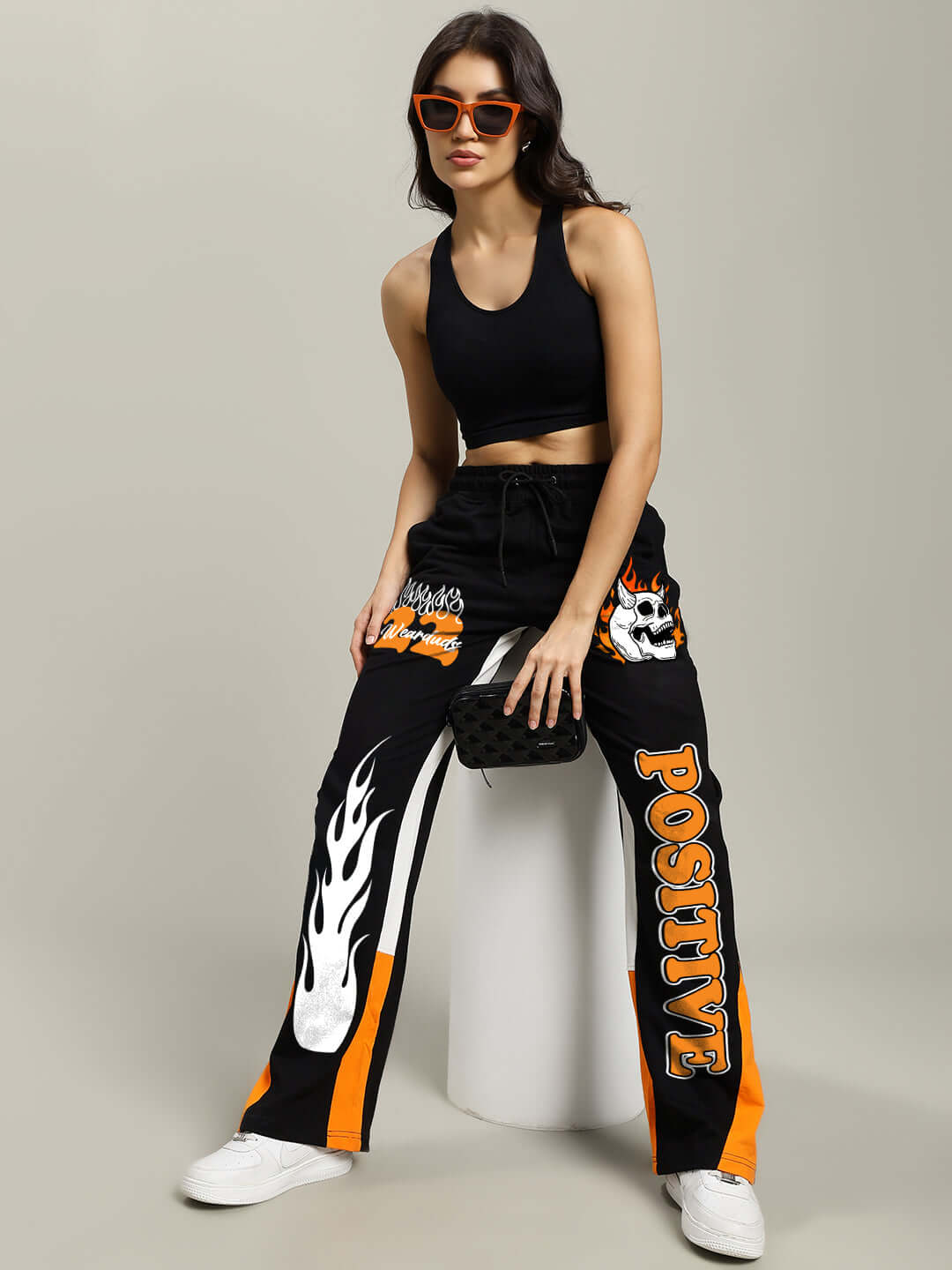 Woman wearing WOMENS FEARLESS CONTRAST RELAXED FIT JOGGERS BLACK-ORANGE with sporty contrast detailing, stylish streetwear.
