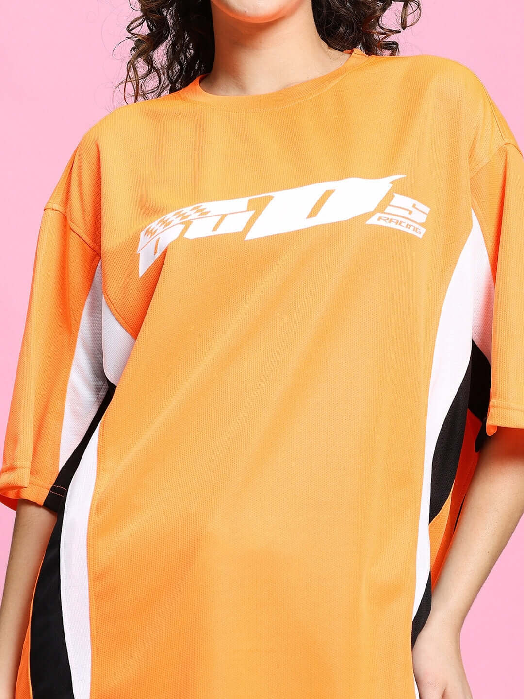 Model wearing WOMEN'S FIFA COLORBLOCK CO-ORD SET ORANGE with vibrant sports design, showcasing activewear style.