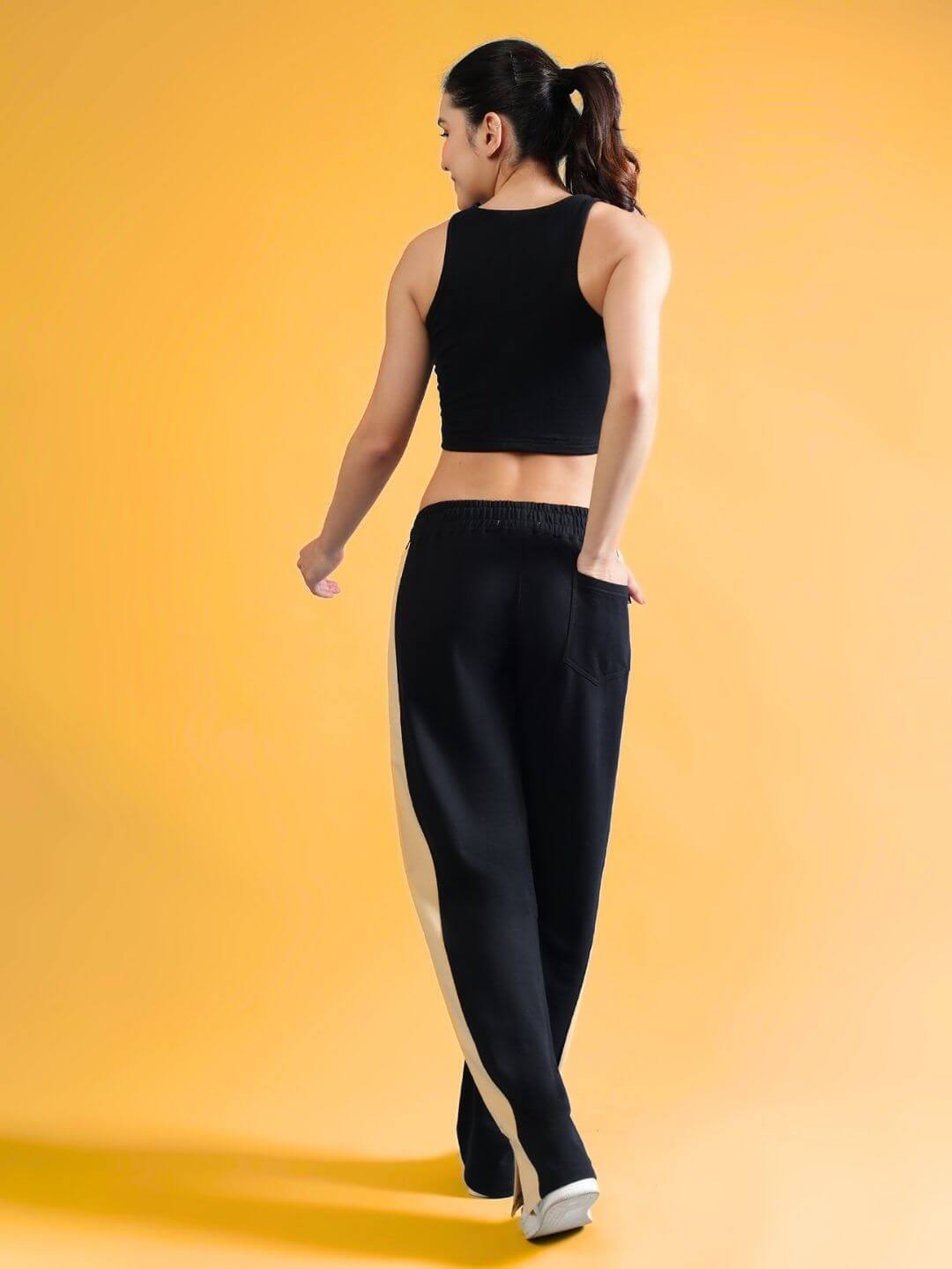 Model wearing WOMEN'S FITFINITY CO-ORD SET BLACK with joggers and black top, showcasing back view.