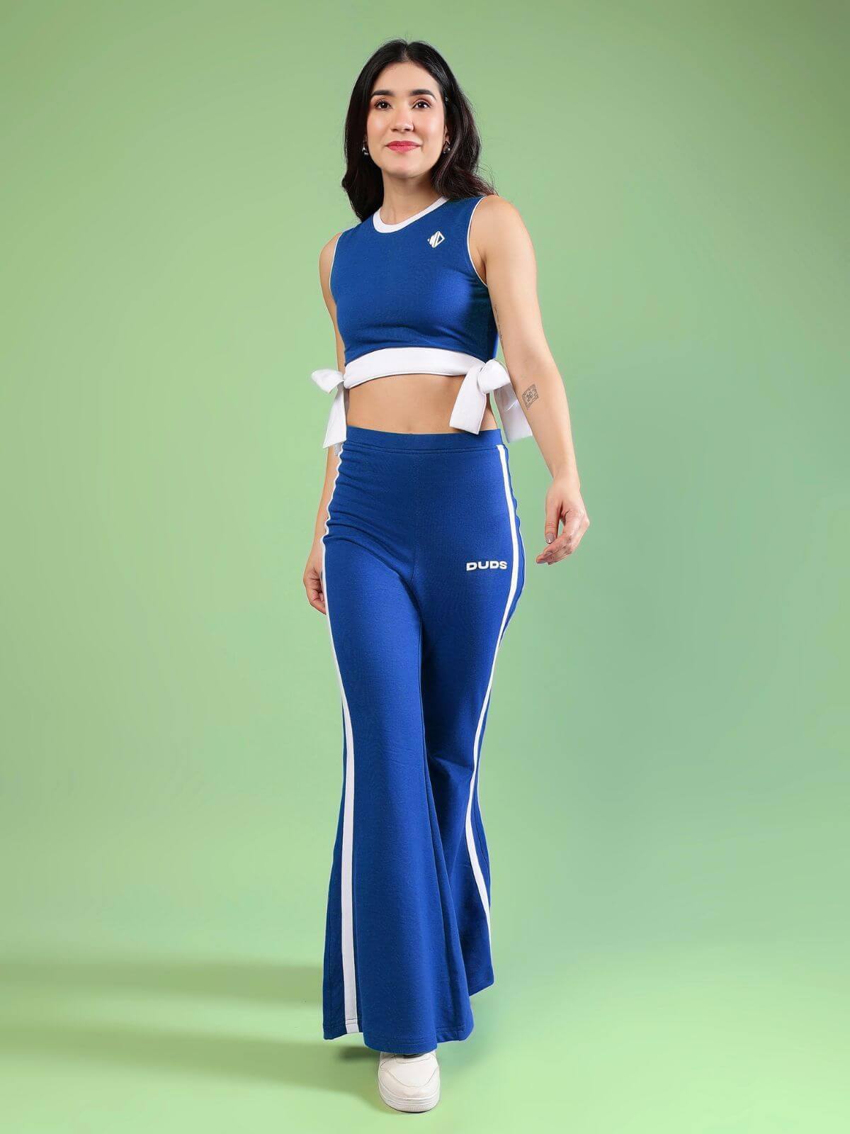 WOMENS FITTONIA COOL CO-ORD SET BLUE worn by model on green background, showcasing chic sporty style.