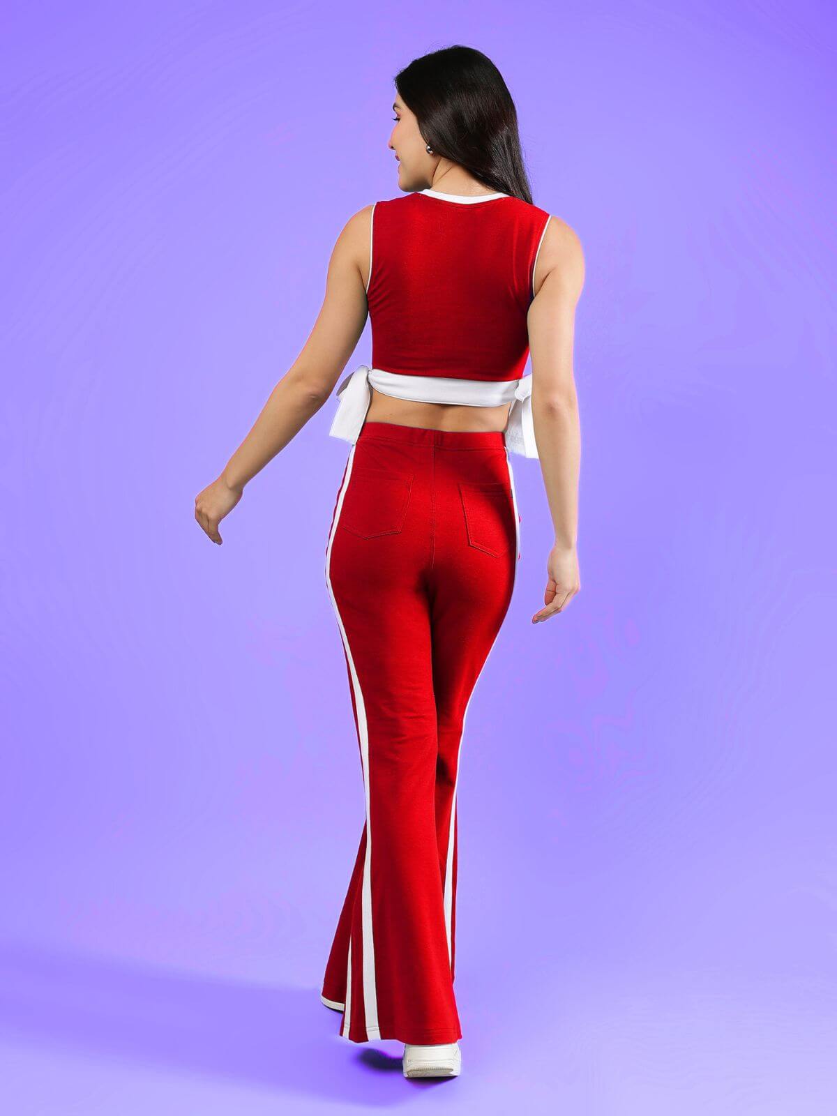 WOMENS FITTONIA COOL CO-ORD SET RED worn by a woman from the back, showcasing the trendy red outfit against a purple background.