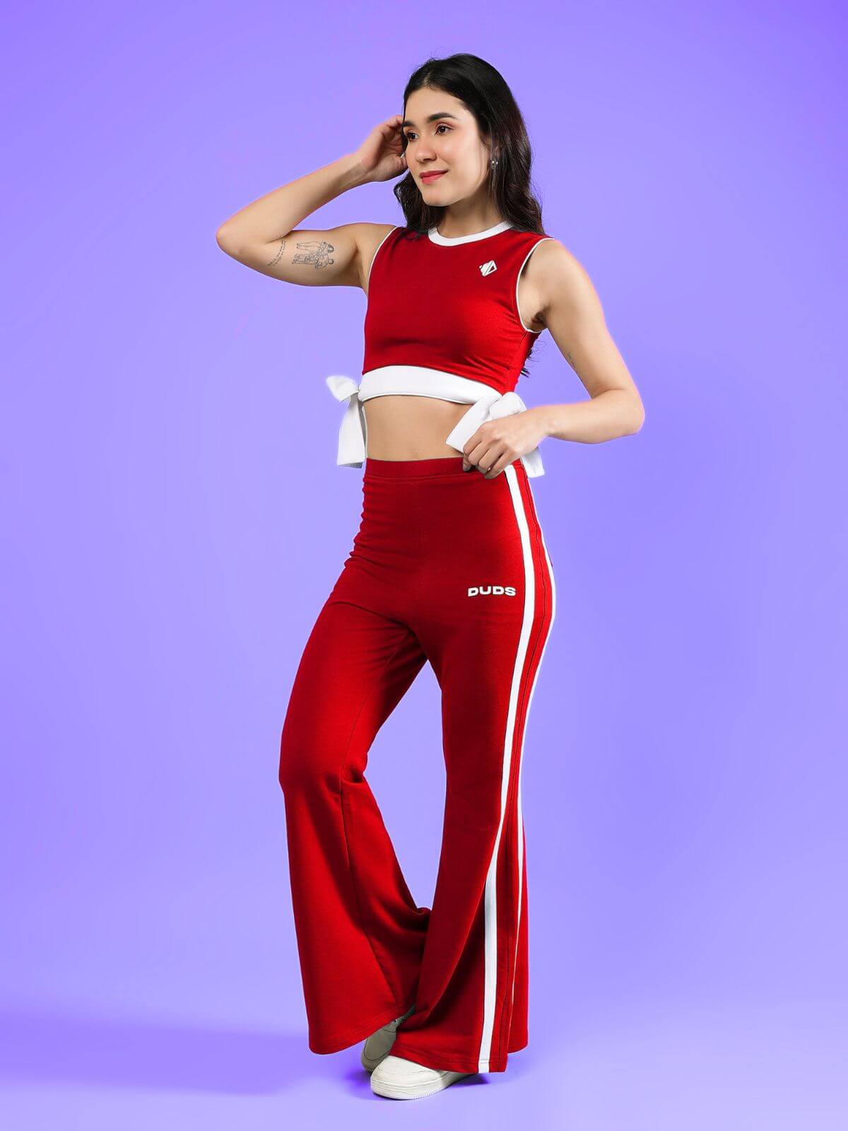 WOMENS FITTONIA COOL CO-ORD SET RED worn by a model against a purple background, showcasing a stylish outfit.