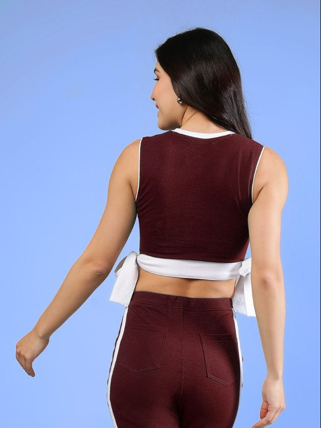 WOMENS FITTONIA COOL CROP TOP MAROON worn by model showcasing back view against a blue background.