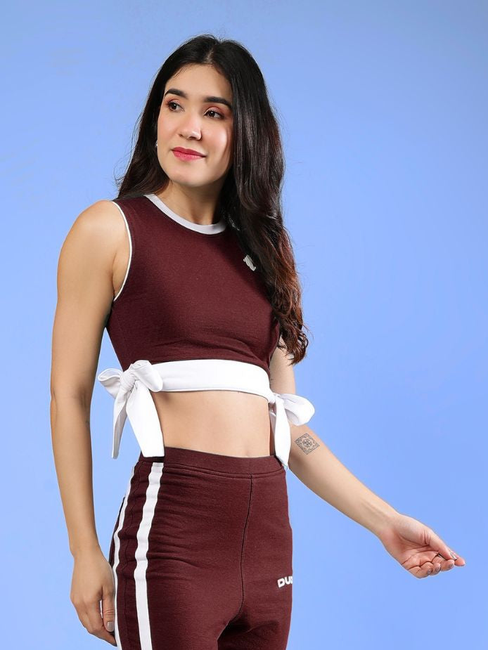 WOMENS FITTONIA COOL CROP TOP MAROON worn by a model with a stylish design and ties at the waist, showcasing modern fashion.