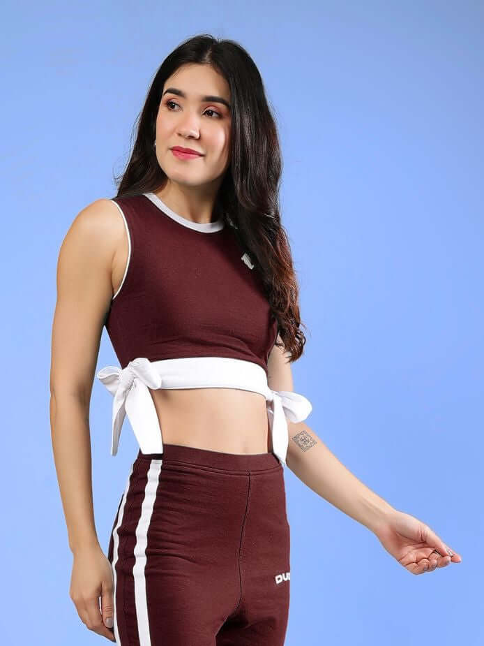WOMENS FITTONIA COOL CROP TOP MAROON worn by a model with a stylish design and ties at the waist, showcasing modern fashion.
