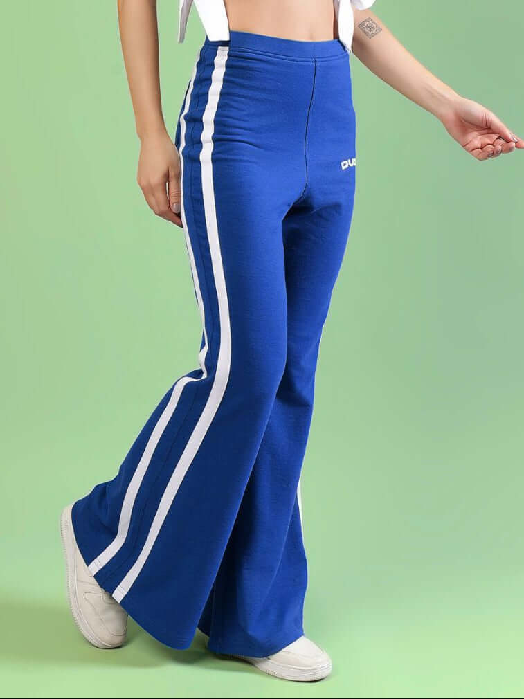 WOMENS FITTONIA COOL WIDE FLARE JOGGERS BLUE being worn by a model against a green background.