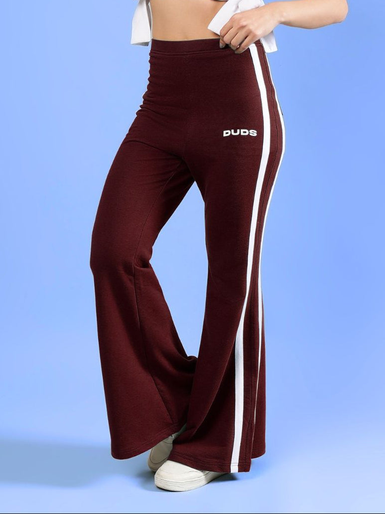 WOMENS FITTONIA COOL WIDE FLARE JOGGERS MAROON displayed by a model with a light blue background